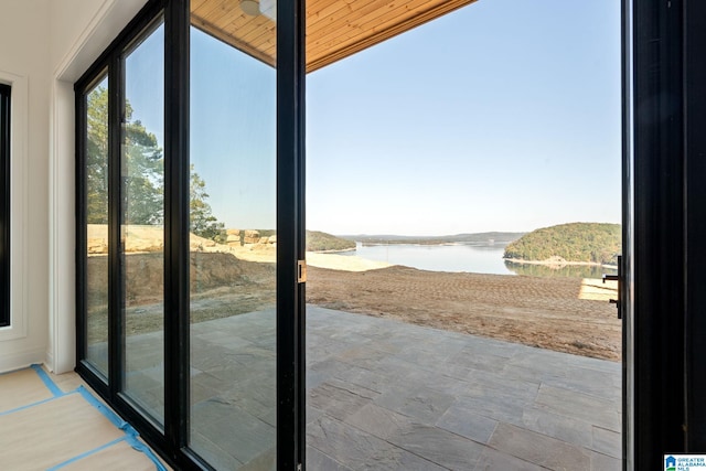 doorway to outside featuring a water view and wooden ceiling