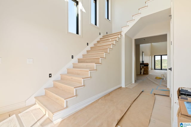 stairway featuring a high ceiling and hardwood / wood-style flooring