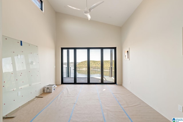 empty room featuring ceiling fan and high vaulted ceiling