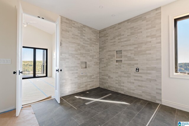 interior space with french doors, tile walls, and lofted ceiling