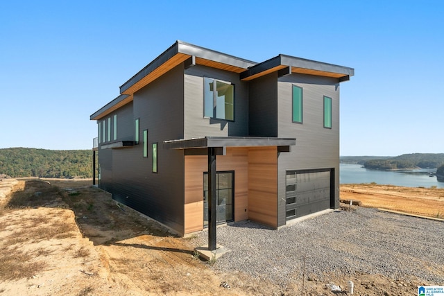 exterior space with a garage and a water view