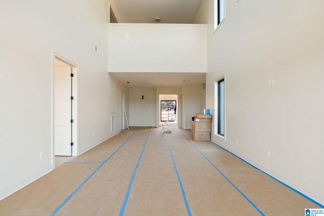 hallway featuring a towering ceiling