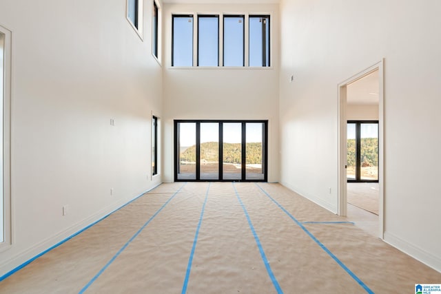 unfurnished living room with basketball court and a high ceiling