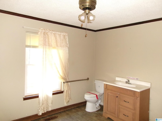 bathroom featuring vanity, a textured ceiling, crown molding, wood-type flooring, and toilet