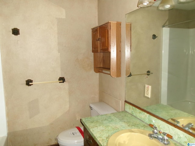 bathroom featuring walk in shower, vanity, and toilet