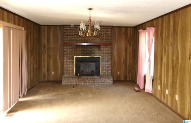 unfurnished living room featuring a notable chandelier, wood walls, and a fireplace