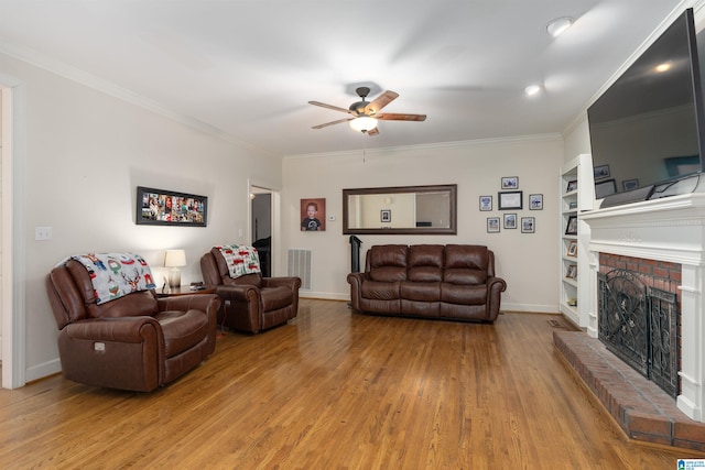 living room with ceiling fan, light hardwood / wood-style floors, crown molding, and a fireplace