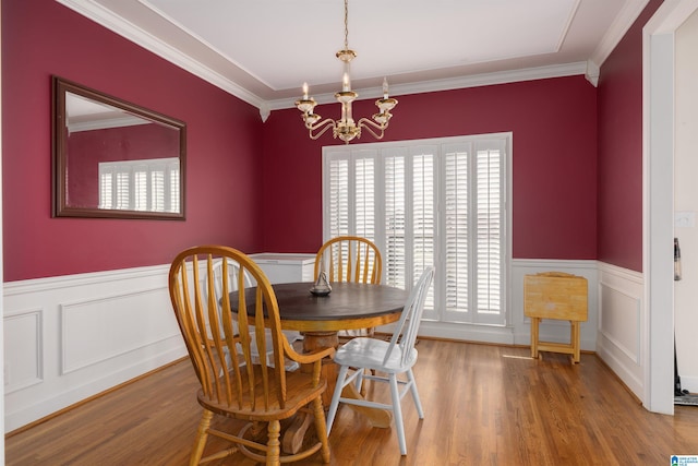 dining space featuring a chandelier, hardwood / wood-style flooring, and ornamental molding