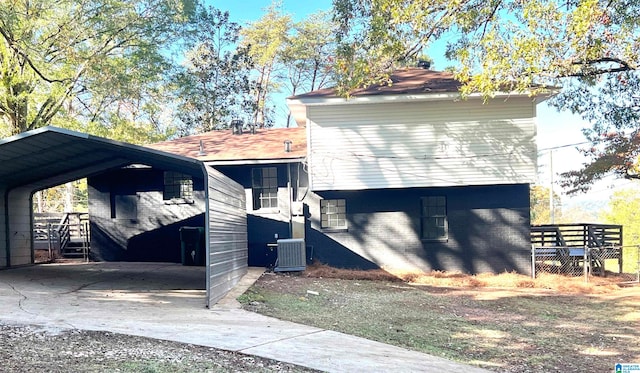 view of side of home with central air condition unit and a carport