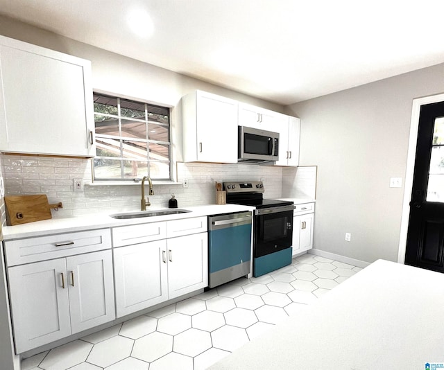 kitchen with decorative backsplash, sink, white cabinets, and stainless steel appliances