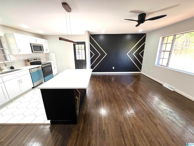 kitchen featuring white cabinetry, sink, hanging light fixtures, stainless steel appliances, and hardwood / wood-style flooring