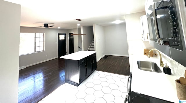 kitchen featuring ceiling fan, sink, and wood-type flooring