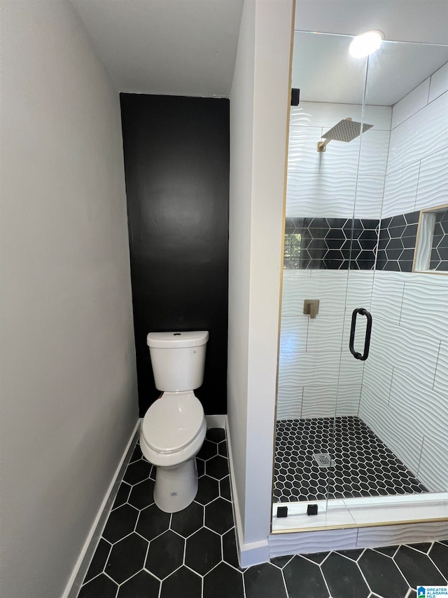 bathroom with tile patterned flooring, toilet, and an enclosed shower