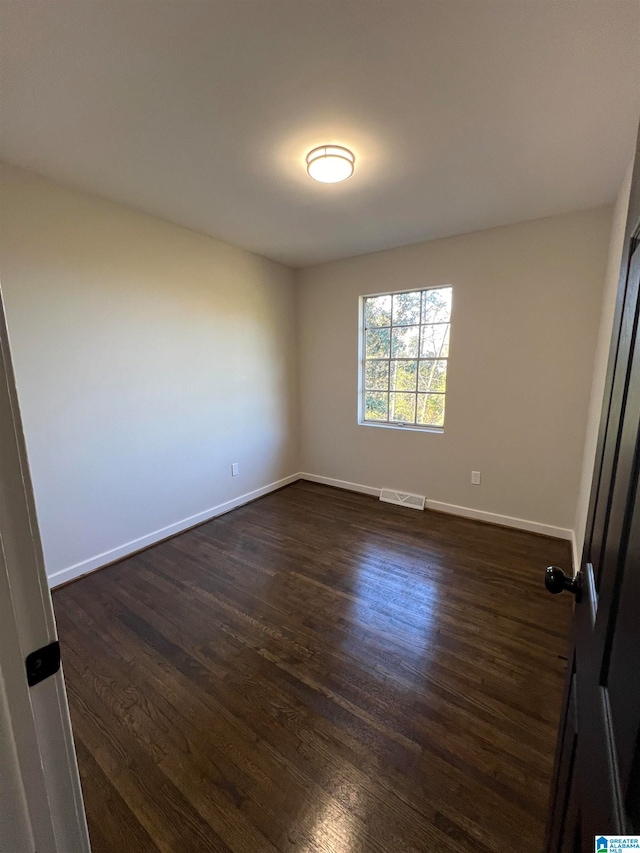 spare room with dark hardwood / wood-style floors