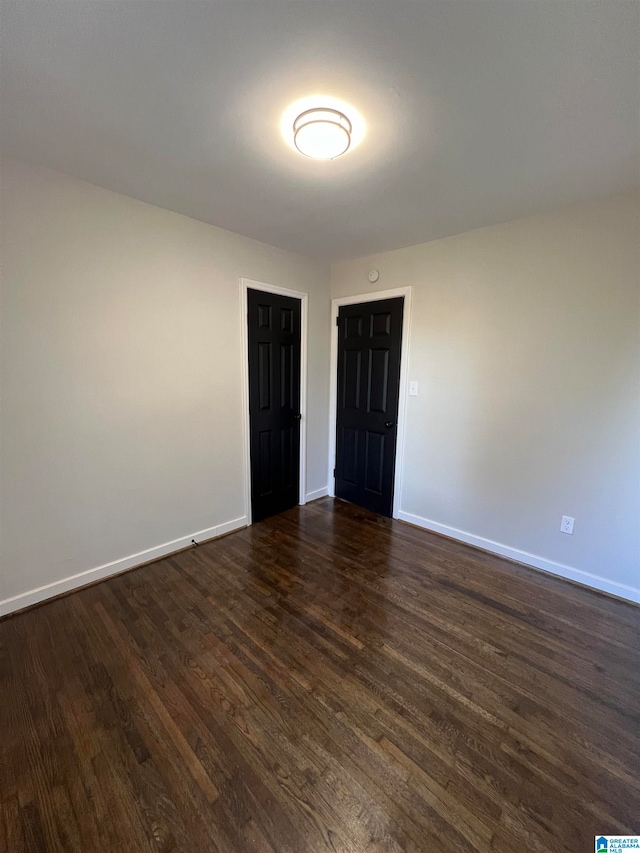 spare room with dark wood-type flooring