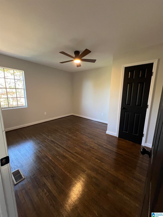 empty room with ceiling fan and dark wood-type flooring