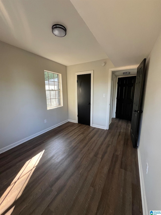 unfurnished bedroom featuring dark wood-type flooring