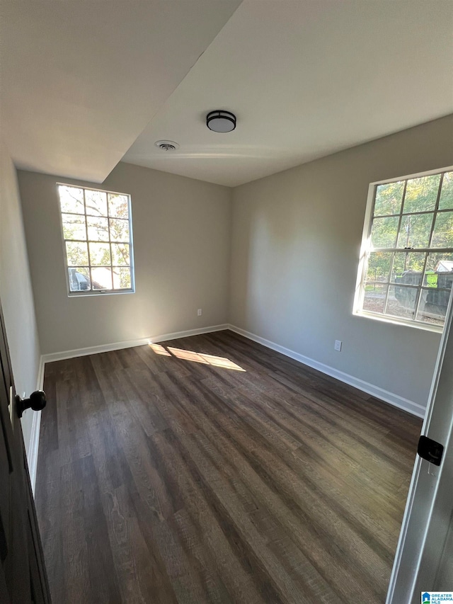 spare room featuring dark wood-type flooring