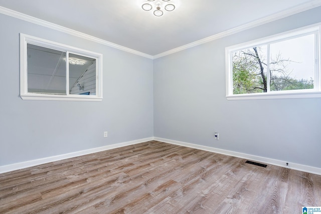 spare room featuring ornamental molding and light wood-type flooring