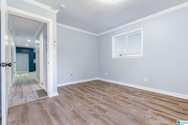 unfurnished room with ornamental molding and light wood-type flooring