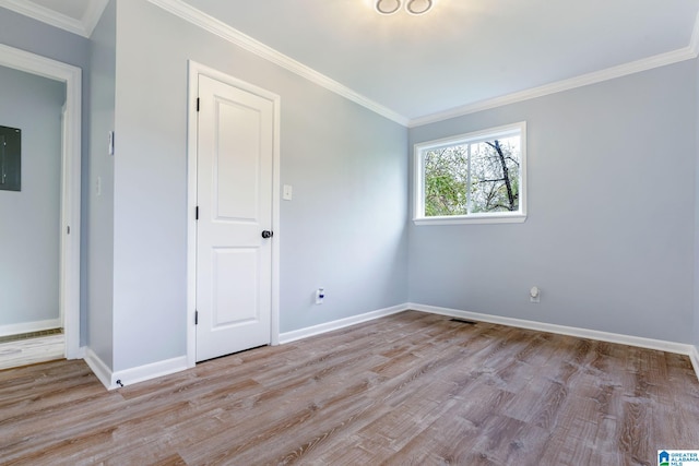 unfurnished room with electric panel, crown molding, and light hardwood / wood-style flooring