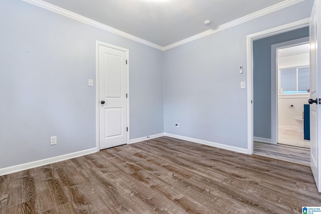 spare room featuring hardwood / wood-style floors and ornamental molding