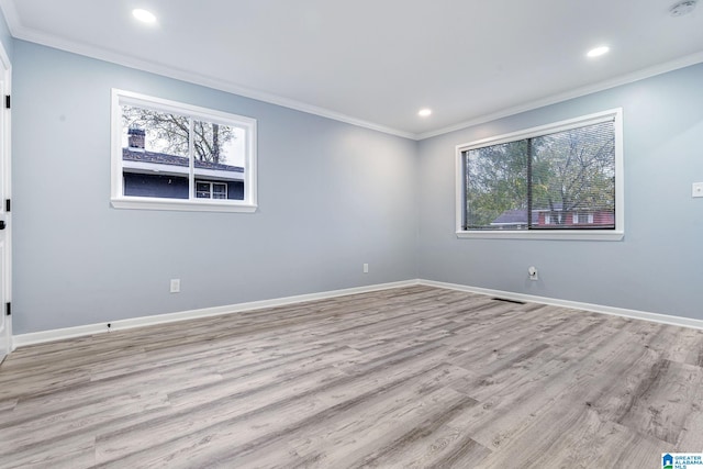 spare room with crown molding and light hardwood / wood-style flooring