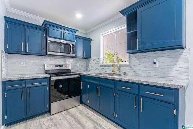 kitchen featuring appliances with stainless steel finishes, ornamental molding, blue cabinets, sink, and light hardwood / wood-style flooring