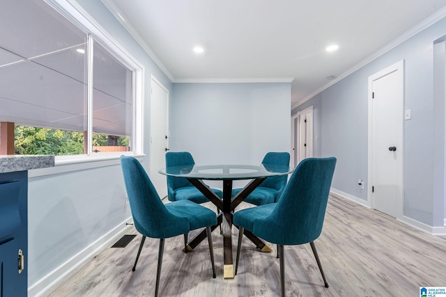 dining area featuring crown molding and light hardwood / wood-style flooring