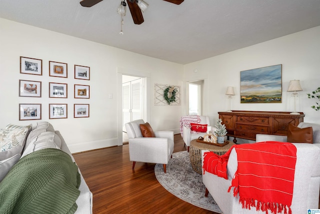 living room with dark hardwood / wood-style flooring and ceiling fan