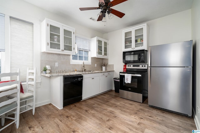 kitchen with black appliances, white cabinets, sink, decorative backsplash, and light hardwood / wood-style floors