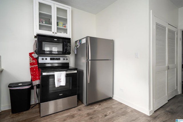 kitchen featuring appliances with stainless steel finishes, light wood-type flooring, and white cabinetry