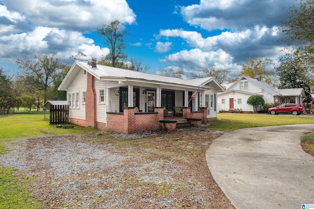 view of front facade featuring covered porch and a front lawn