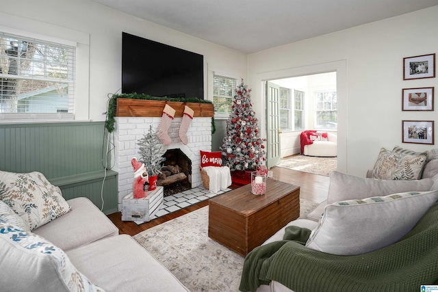 living room featuring a wealth of natural light, a fireplace, and wood-type flooring