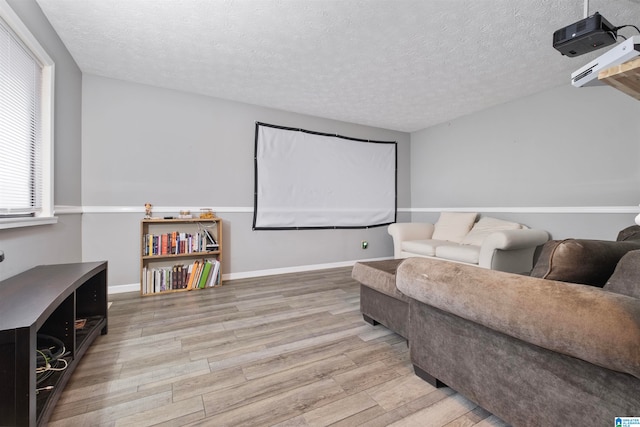 cinema featuring a textured ceiling and light hardwood / wood-style flooring