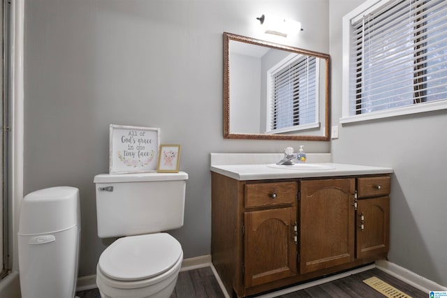 bathroom with toilet, vanity, and hardwood / wood-style flooring