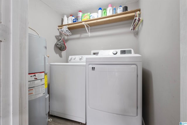 laundry area featuring a textured ceiling, electric water heater, hardwood / wood-style flooring, and washer and clothes dryer