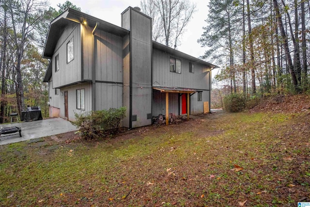 view of side of home featuring a patio area and a yard