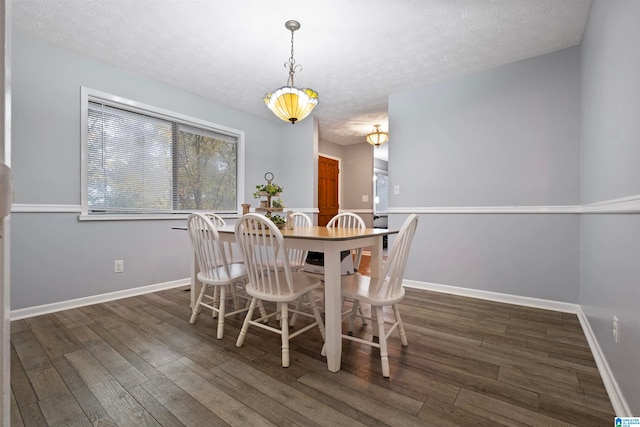 dining space with dark hardwood / wood-style flooring and a textured ceiling