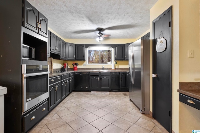 kitchen with black appliances, sink, ceiling fan, a textured ceiling, and light tile patterned flooring