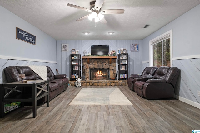 living room featuring hardwood / wood-style floors, a textured ceiling, and wooden walls