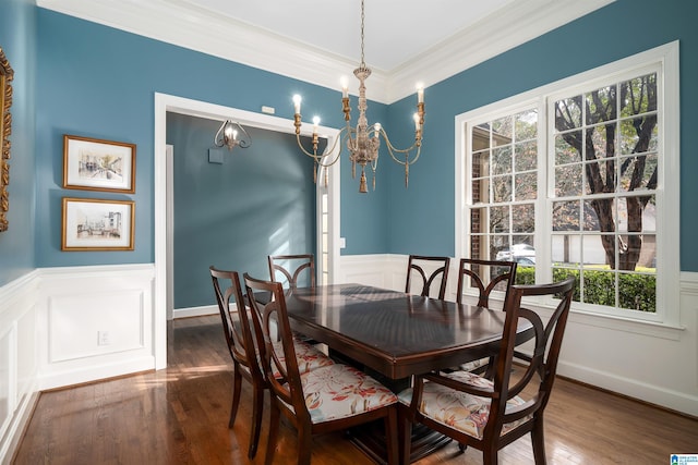 dining space with a wainscoted wall, a notable chandelier, dark wood-style flooring, and crown molding