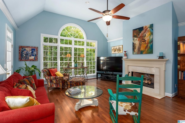 living room with a high end fireplace, vaulted ceiling, ceiling fan, crown molding, and hardwood / wood-style floors