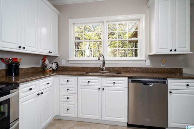 kitchen with dark stone counters, white cabinetry, sink, and stainless steel appliances