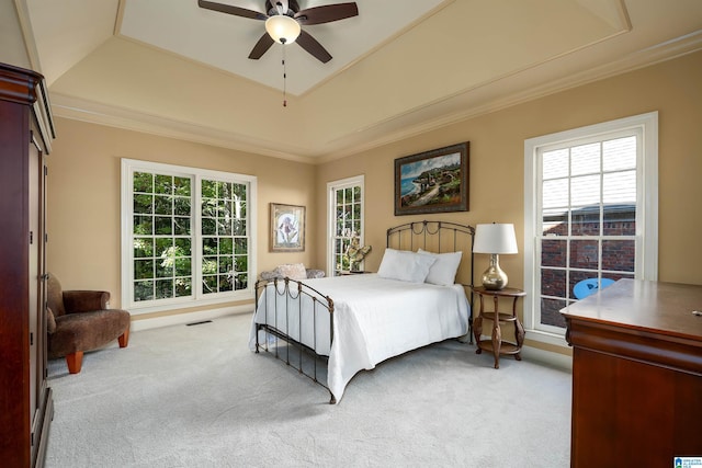 bedroom with multiple windows, ceiling fan, and light colored carpet