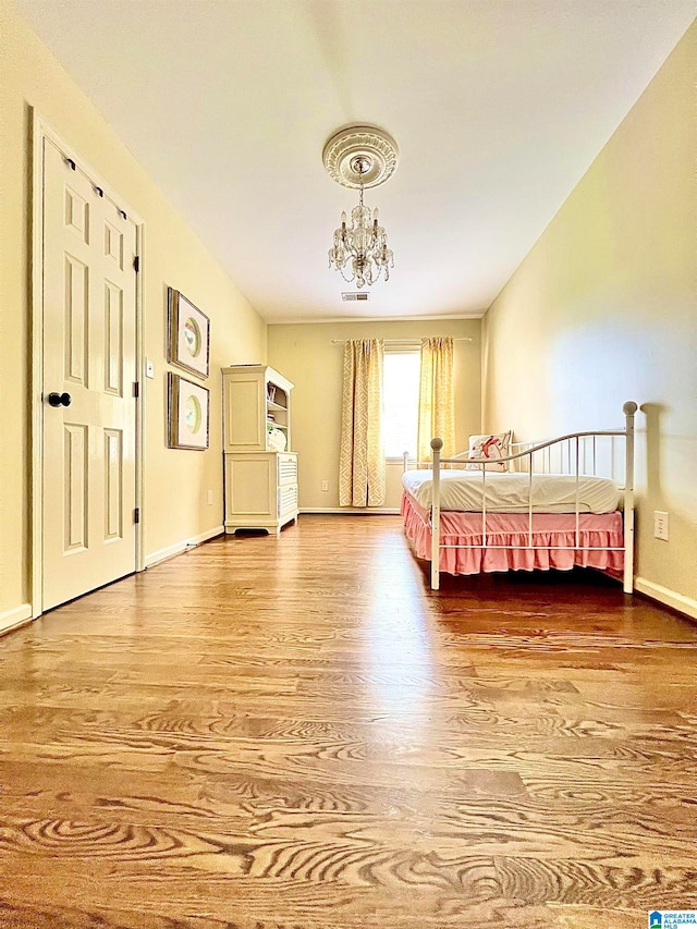 unfurnished bedroom with hardwood / wood-style flooring and a notable chandelier