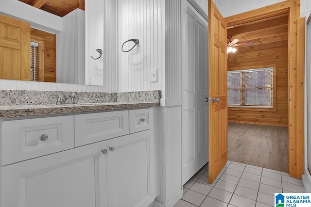 bathroom with hardwood / wood-style floors, vanity, wood walls, wooden ceiling, and ceiling fan