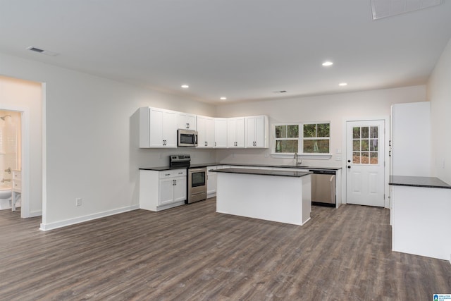 kitchen with stainless steel appliances, sink, a center island, dark hardwood / wood-style floors, and white cabinetry