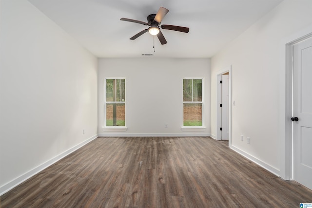 spare room featuring dark hardwood / wood-style flooring, ceiling fan, and a healthy amount of sunlight