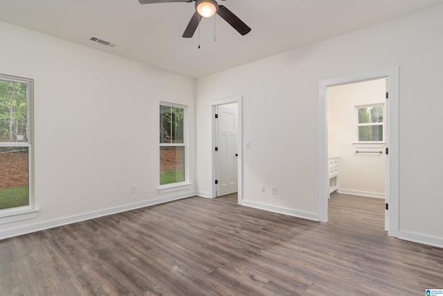 unfurnished room with dark hardwood / wood-style floors, a healthy amount of sunlight, and ceiling fan